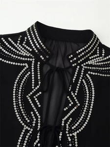 Close-up of black chiffon shirt neckline with silver sequins and lace-up detail