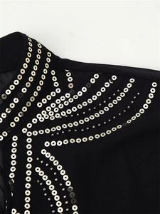 Macro detail of geometric silver sequins and black beadwork on the shoulder of the shirt