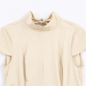 Detail view of beige elegant dress featuring high neck collar with a decorative back bow tie