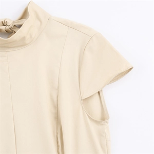 Detailed view of apricot dress featuring elegant high neck and tied bow back detail