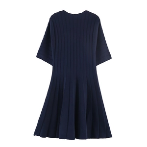 Macro detail of navy short sleeve dress showing vertical ribbed knit and pleated skirt texture