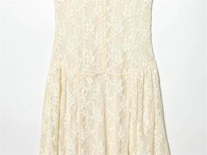 Détails de la robe en dentelle beige avec motifs floraux et coutures précises à la taille