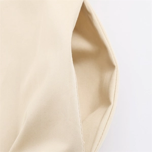 Close-up detail of side pocket on beige cotton twill dress showing fine stitching