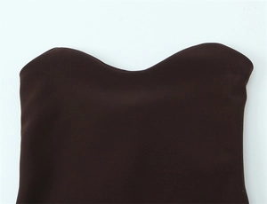 Dettaglio dello scollo ondulato e del tessuto marrone cioccolato liscio dell'abito