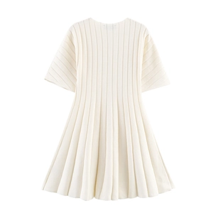 Close-up of cream white ribbed knit dress fabric showing vertical texture and stitching