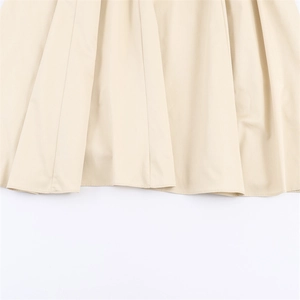 Detailed macro view of the pleated light beige fabric texture on the stylish skirt hem