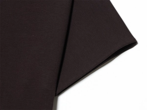 Detailed macro view of dark coffee cotton knit fabric showing premium texture and density