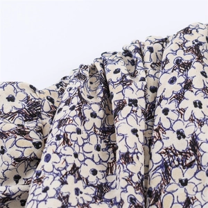 Gros plan sur tissu plissé léger avec imprimé floral artistique et contours violets