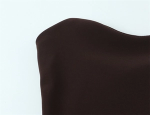 Vista dettagliata del tessuto marrone scuro e dello scollo dell'abito corto a pois