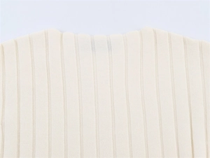 Macro detail of creamy ribbed knit neckline showing high-quality texture and stitching