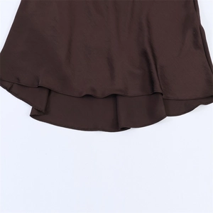 Macro detail of dark brown satin dress hem featuring elegant double-layered ruffles