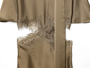 Detailed macro view of dark khaki satin dress fabric with delicate eyelash lace trim