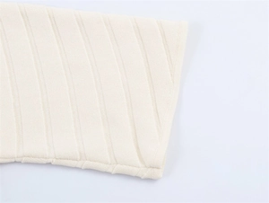 Close-up of vertical ribbed knit texture on a cream-colored short sleeve dress