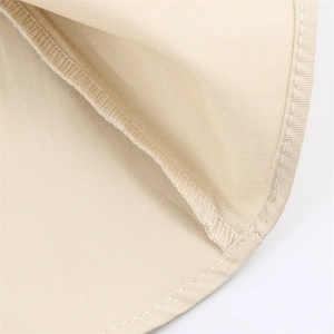Close-up of beige fabric showing high-quality stitching and reinforced edge details