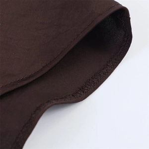 Macro detail of fine stitching and overlock seams on dark brown satin dress fabric