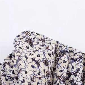 Gros plan sur le tissu à fleurs avec motifs crème et détails de texture légère