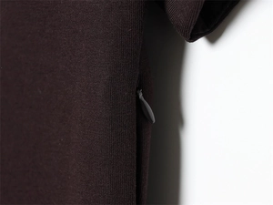 Close-up of invisible zipper detail on dark brown knit dress with fine texture