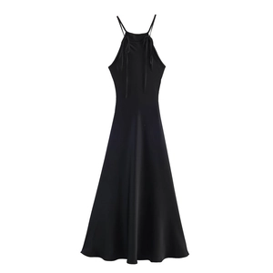 Detail of black satin halter dress showing slim straps and silky fabric texture