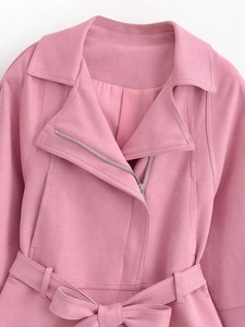 Gros plan d'une veste en daim rose avec fermeture éclair et ceinture assortie à la taille