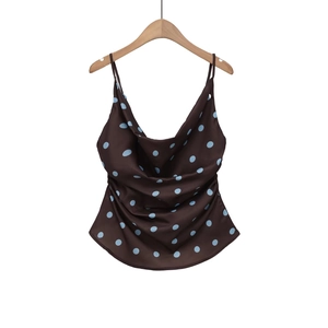 Detail of satin cowl neck camisole in dark brown with blue polka dots on a hanger