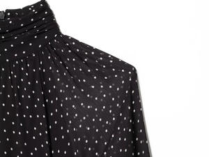 Detail of high neck pleated chiffon dress with polka dot pattern and back zipper