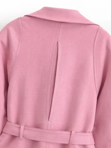 Détail du dos d'une veste rose en suédine avec fente arrière et ceinture assortie