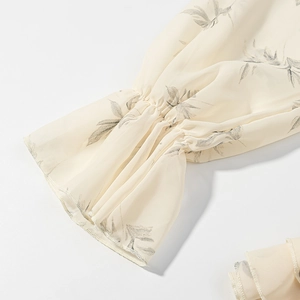 Dettaglio del polsino con volant elastico su un abito a fiori in chiffon beige