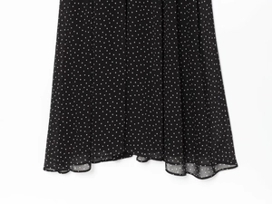 Detail of polka dot chiffon dress hemline featuring lightweight semi-sheer fabric