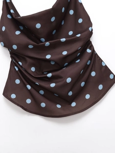 Detail of a brown polka dot camisole showing silk texture and cowl neck design