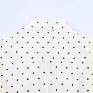 Detail of white polka dot poplin shirt showing neckline stitching and fabric texture