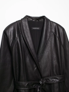 Detailed view of black faux leather coat with notched lapels and branded neck label