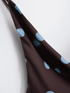 Macro detail of silky brown fabric with light blue polka dots and smooth texture