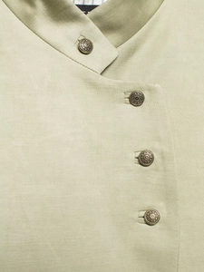 Detail of light green Chinese style blazer with metal buttons and textured fabric