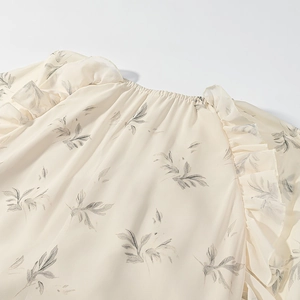 Dettaglio dell'abito in chiffon a fiori con scollo elastico e volant sulla spalla