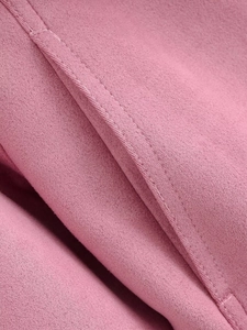 Détail macro de la texture du velours rose et de la qualité des coutures soignées