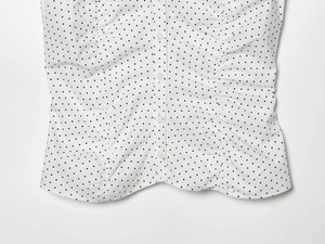 Detail der weißen Polka-Dot-Bluse mit Vorderknöpfen und gerafftem Seitendesign