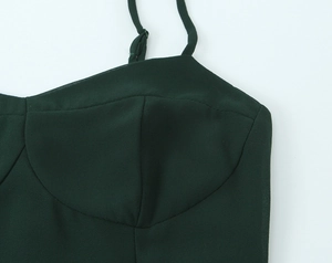 Détail de la robe vert foncé montrant les bretelles réglables et la poitrine structurée