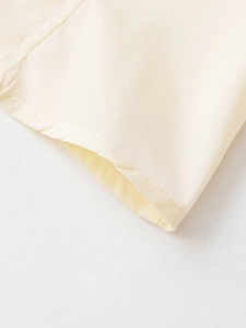 Détail rapproché de la couture de précision sur la manche d'une chemise en popeline jaune