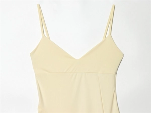 Détail d'un caraco beige clair avec fines doubles bretelles et décolleté en V épuré