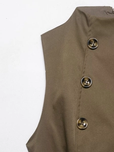 Detailed close-up of khaki sleeveless top featuring twill texture and tortoiseshell buttons