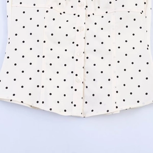 Detail of white poplin shirt featuring black polka dots and white buttons on front