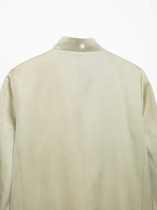 Detailed close-up of the collar and back stitching on this pale green blazer jacket
