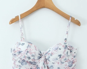 Detail of seashell and coral print on white spaghetti strap top with knotted bust