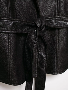 Close-up of black leather coat texture showing pebbled grain and tied waist belt