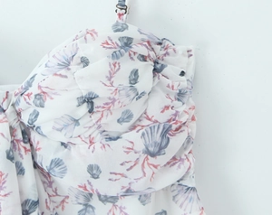 Detailed close-up of floral marine print dress with ruffled chest and adjustable straps
