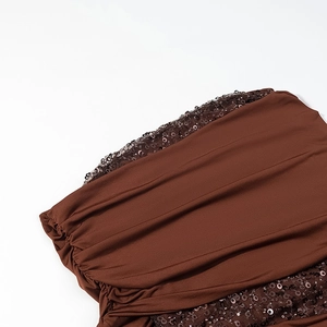 Detailed close-up of dark brown fabric featuring shiny sequins and elegant ruching texture