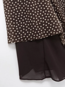 Detailed macro view of the double-layered polka dot fabric and hem on women's skirt
