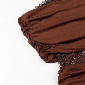 Detail of dark brown sequined fabric with pleated bubble sleeves and draped texture