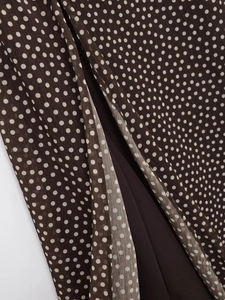 Detailed macro view of polka dot chiffon fabric with asymmetric slit and brown lining