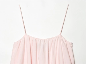 Close-up of light pink dress featuring thin adjustable straps and a side zipper